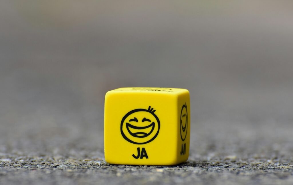 A smiling dice encouraging people to smile because Face Speaks Before Your Words