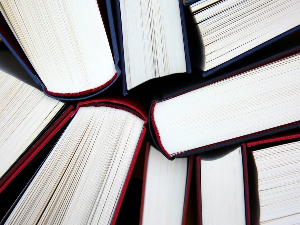 A detailed close-up of a collection of books piled together, highlighting their diverse colors and intricate designs.