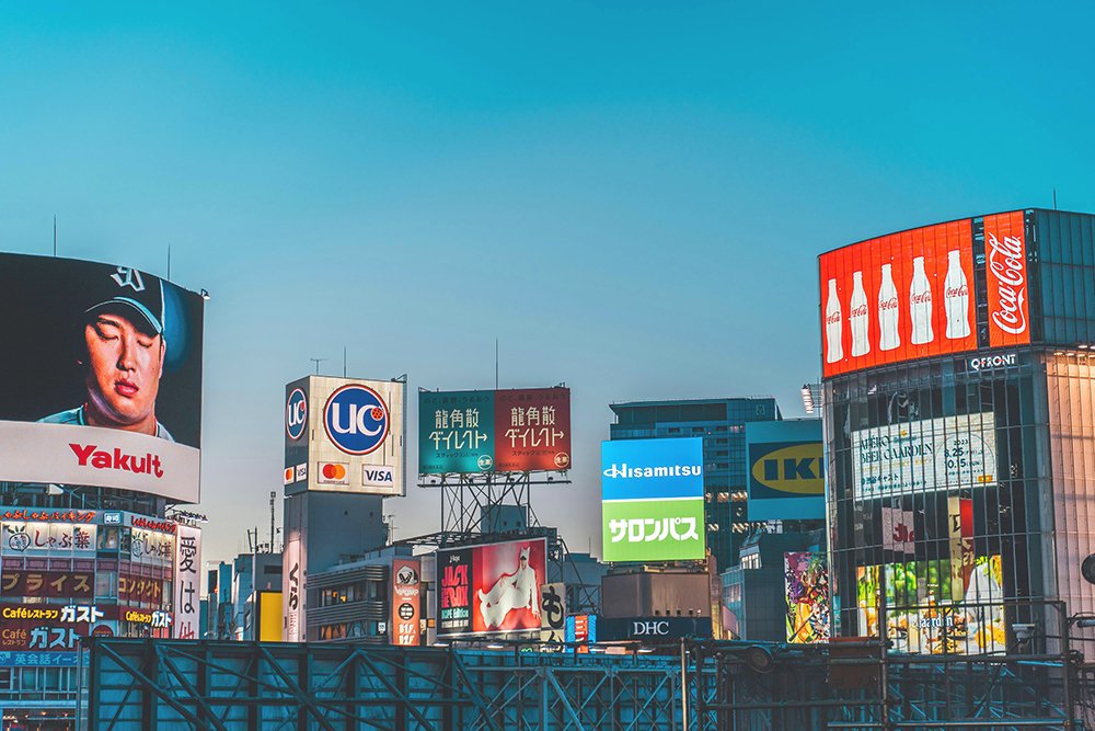 A vibrant city street featuring an array of billboards and advertisements